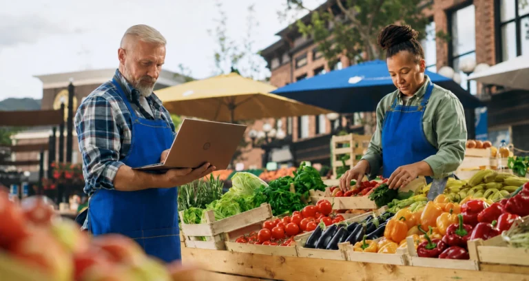 Small business owners at a market for business owners policy insurance