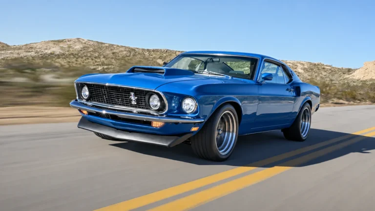 Blue classic Mustang driving on an open road